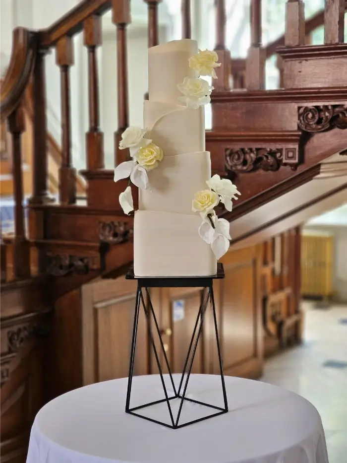4 tier wedding cakes with a mixture of curved corner, square tiers and a round top tier, showcasing 3 arrangements of waferpaper roses and lillies