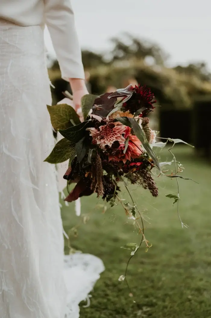 Bold yet muted tall and narrow 5 tier teal wedding cake with striking burnt orange abstract flowers