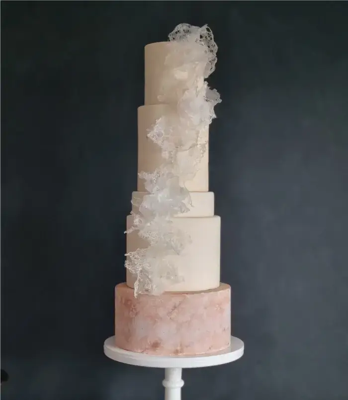 4 tier textured white and blush wedding cake with rice paper lace decor