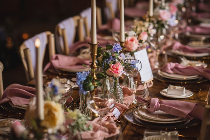 Wedding reception table with flowers running down the middle at Christmas Pie Barns, Surrey