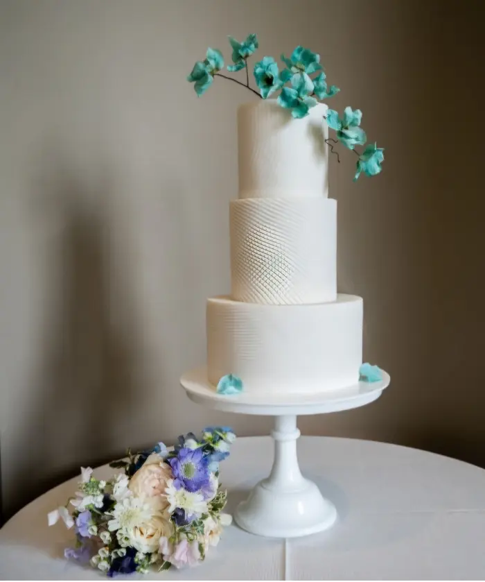 White ceramic effect 3 tier wedding cake with wafer paper flowers at Wilderness Reserve, Suffolk