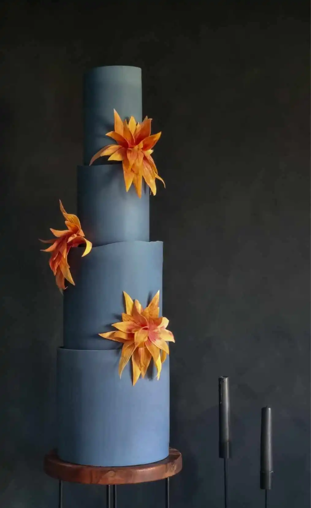 Contemporary tall blue 4 tier wedding cake with striking burnt orange abstract flowers London