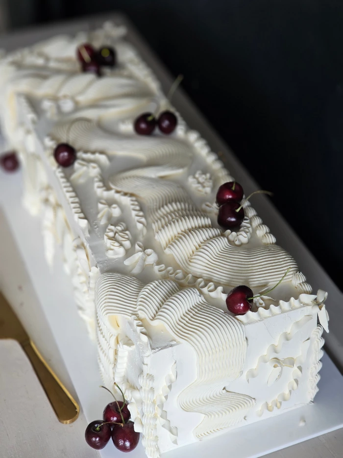 Trending contemporary long sheet cake wedding cake with funky piping and cherry decoration Colours Hoxton London