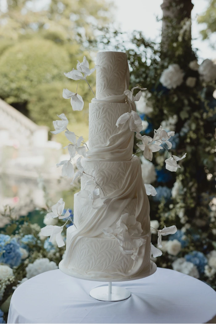 5 tier white on white wedding cake with draping stunning leaf texture, draping and abstract flowers at Euridge Manor, Wiltshire