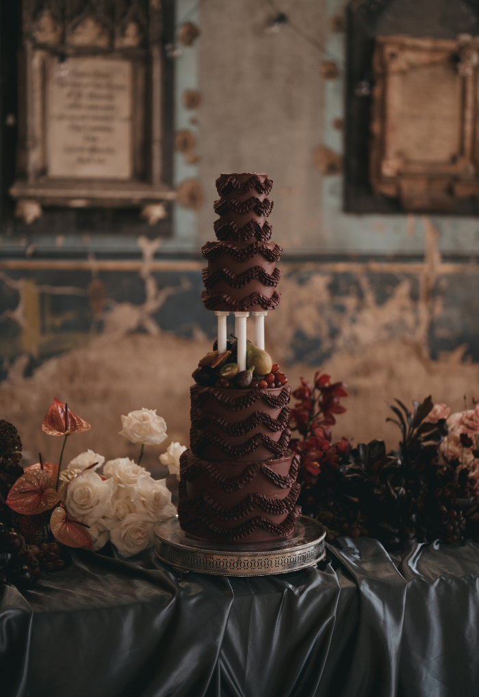 Contemporary burgundy vintage pillar ruffe wedding cake with fruit at Asylum Chapel, Peckham