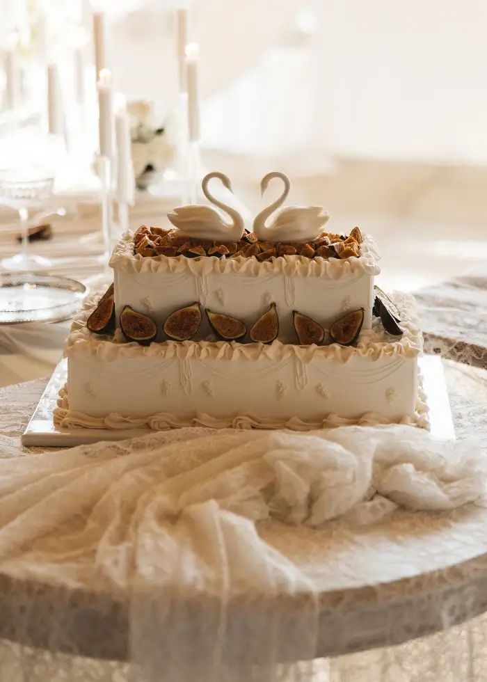 2 tier rectangular wedding cake with traditional piping, figs and swans at The Barn at Botley Hill, Surrey