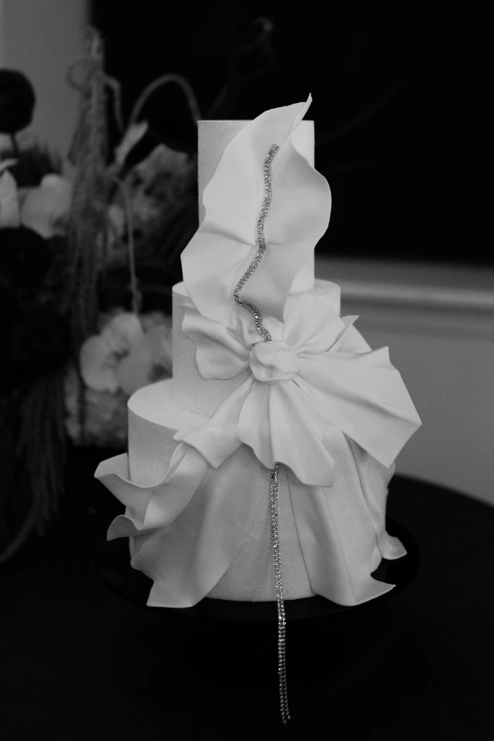 Small 3 tier white couture wedding cake with sculptural sugar  fabric and jewel detail for Langan's Brasserie, London by Sue Hurst Cake Design